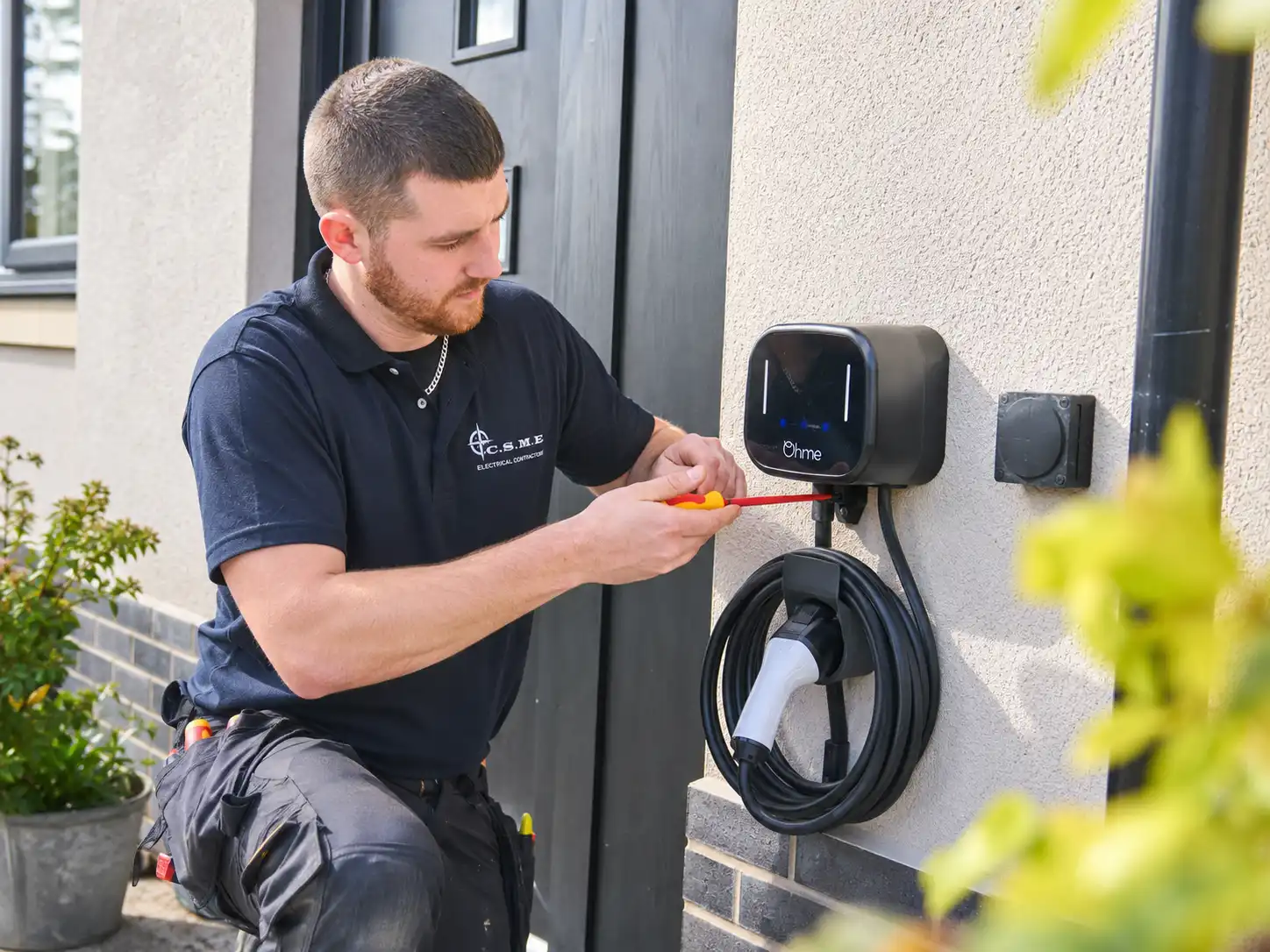 Connor installing an electric vehicle charging unit outside a home